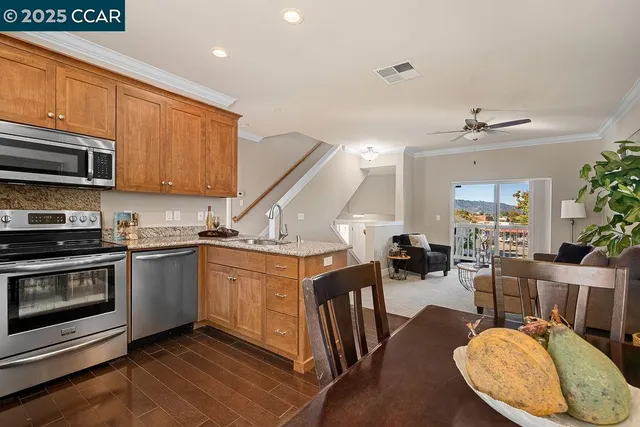 a kitchen with stainless steel appliances kitchen island granite countertop a stove a sink and a microwave