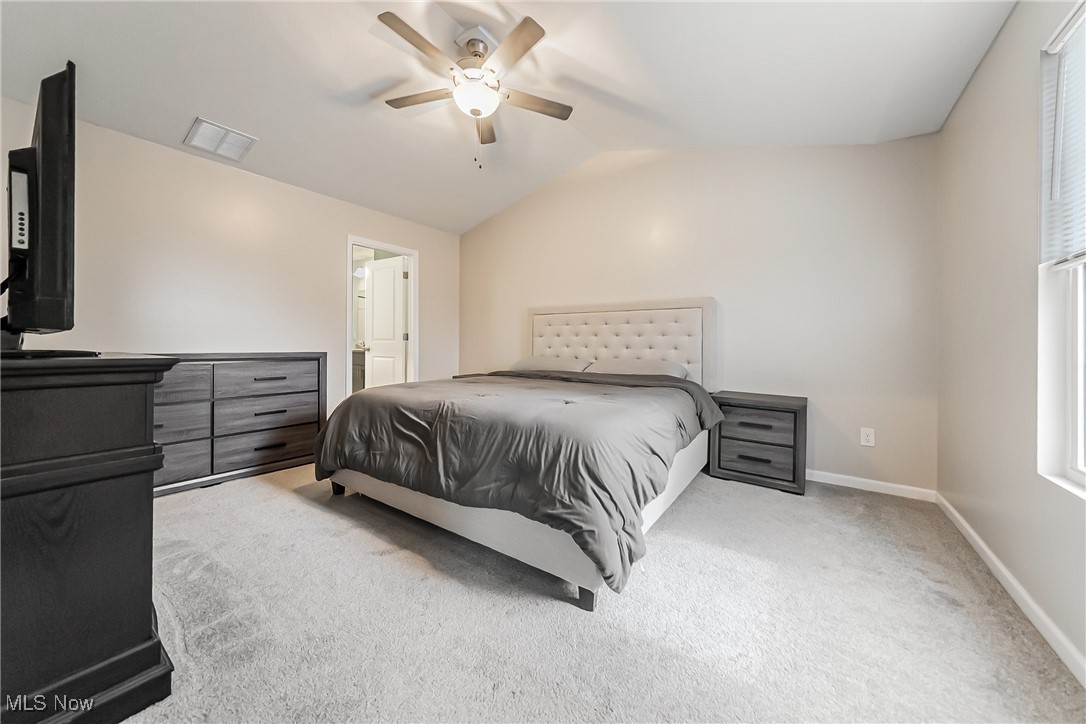 6105 Dunham Road Maple Heights, OH 44137 - Photo 12 of 38 Bedroom featuring vaulted ceiling, carpet flooring, baseboards, a ceiling fan, and ensuite bath