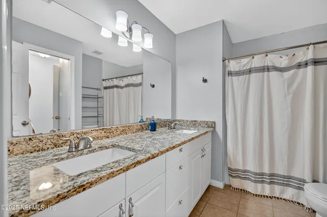 a front view of a house with a garden and trees