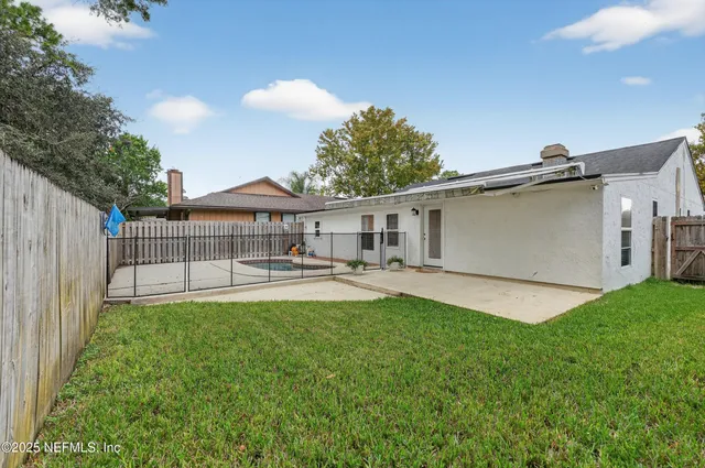 an aerial view of residential house with outdoor space and trees all around