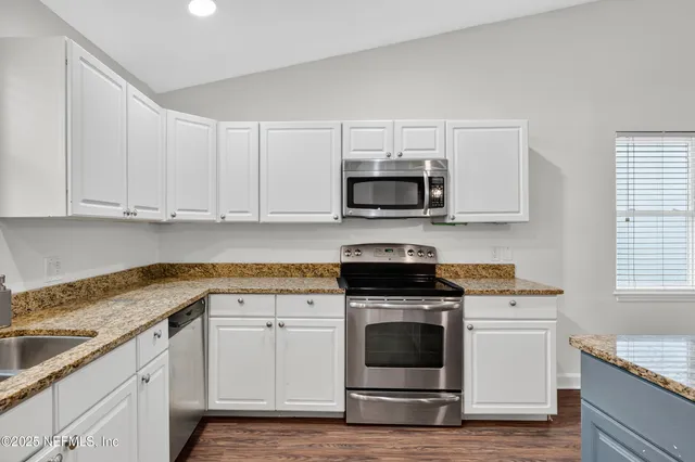 a bathroom with a granite countertop sink a toilet and a mirror