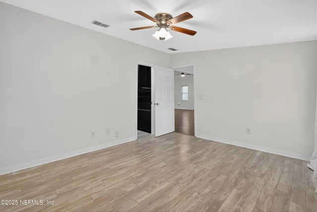 a bedroom with a baby bed a couch and a window