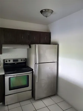 a kitchen with a refrigerator and a stove top oven