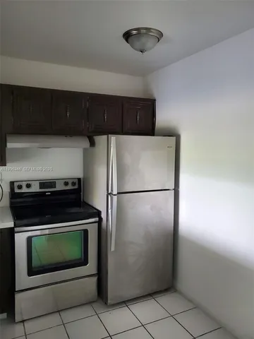 a kitchen with a refrigerator and a stove top oven