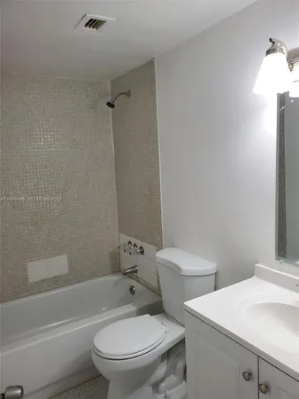 a white toilet sitting next to a bath tub