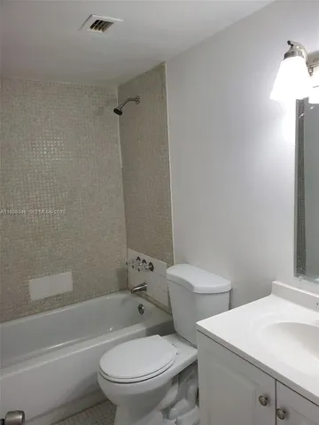 a white toilet sitting next to a bath tub