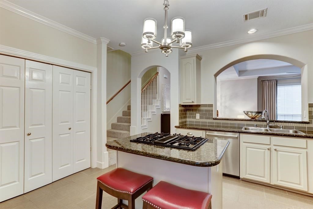 248 Westcott Street Houston, TX 77007 - Photo 20 of 32 a kitchen with stainless steel appliances granite countertop a stove and a chandelier