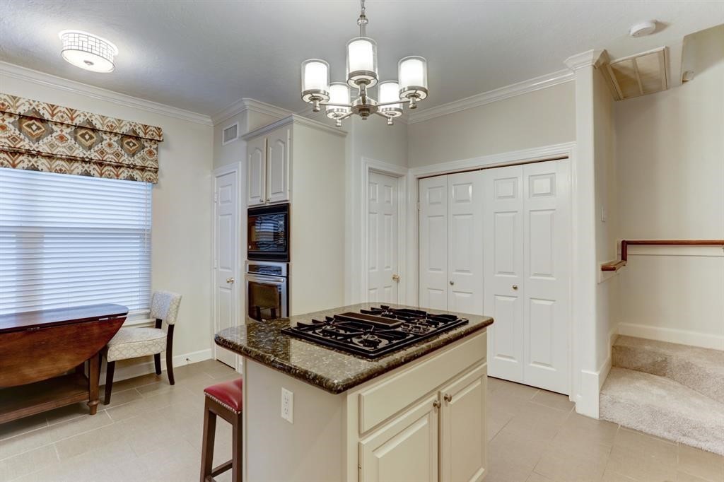 248 Westcott Street Houston, TX 77007 - Photo 21 of 32 a kitchen that has a stove and a chandelier