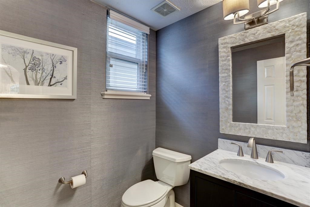 248 Westcott Street Houston, TX 77007 - Photo 24 of 32 a bathroom with a granite countertop toilet sink and mirror