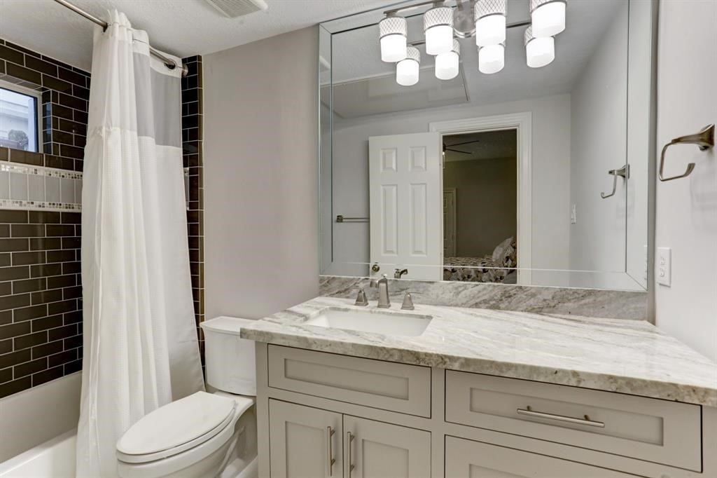 248 Westcott Street Houston, TX 77007 - Photo 31 of 32 a bathroom with a sink a toilet and a mirror