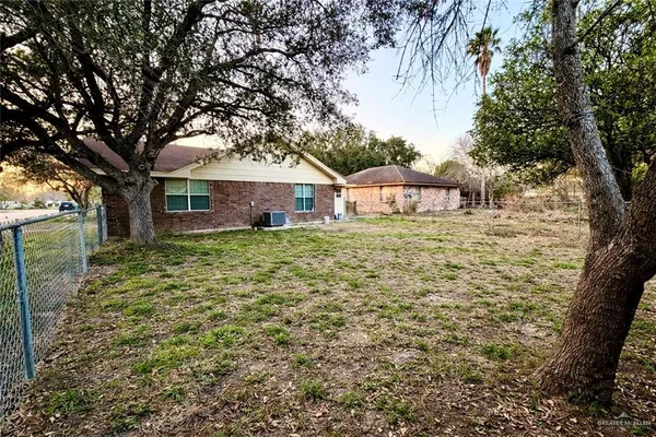 a large brick house with a big yard and large trees