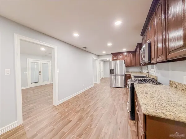 a kitchen with granite countertop wooden floors and wooden cabinets