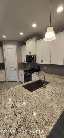 a bathroom with a granite countertop sink a toilet and shower