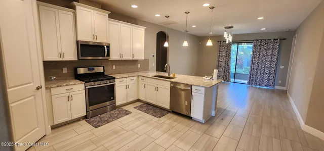 a kitchen with stainless steel appliances kitchen island granite countertop a stove a sink and a microwave