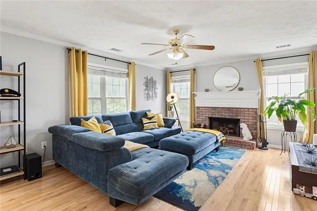 a living room with furniture a fireplace and a large window