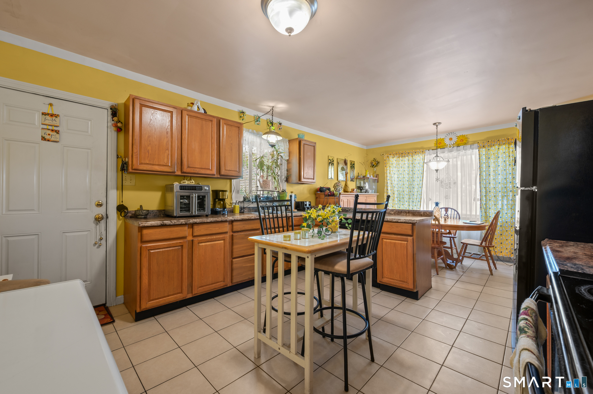 85 Dwight Street Ansonia, CT 06401 - Photo 9 of 40 a open dining room with stainless steel appliances a dining table chairs and a refrigerator