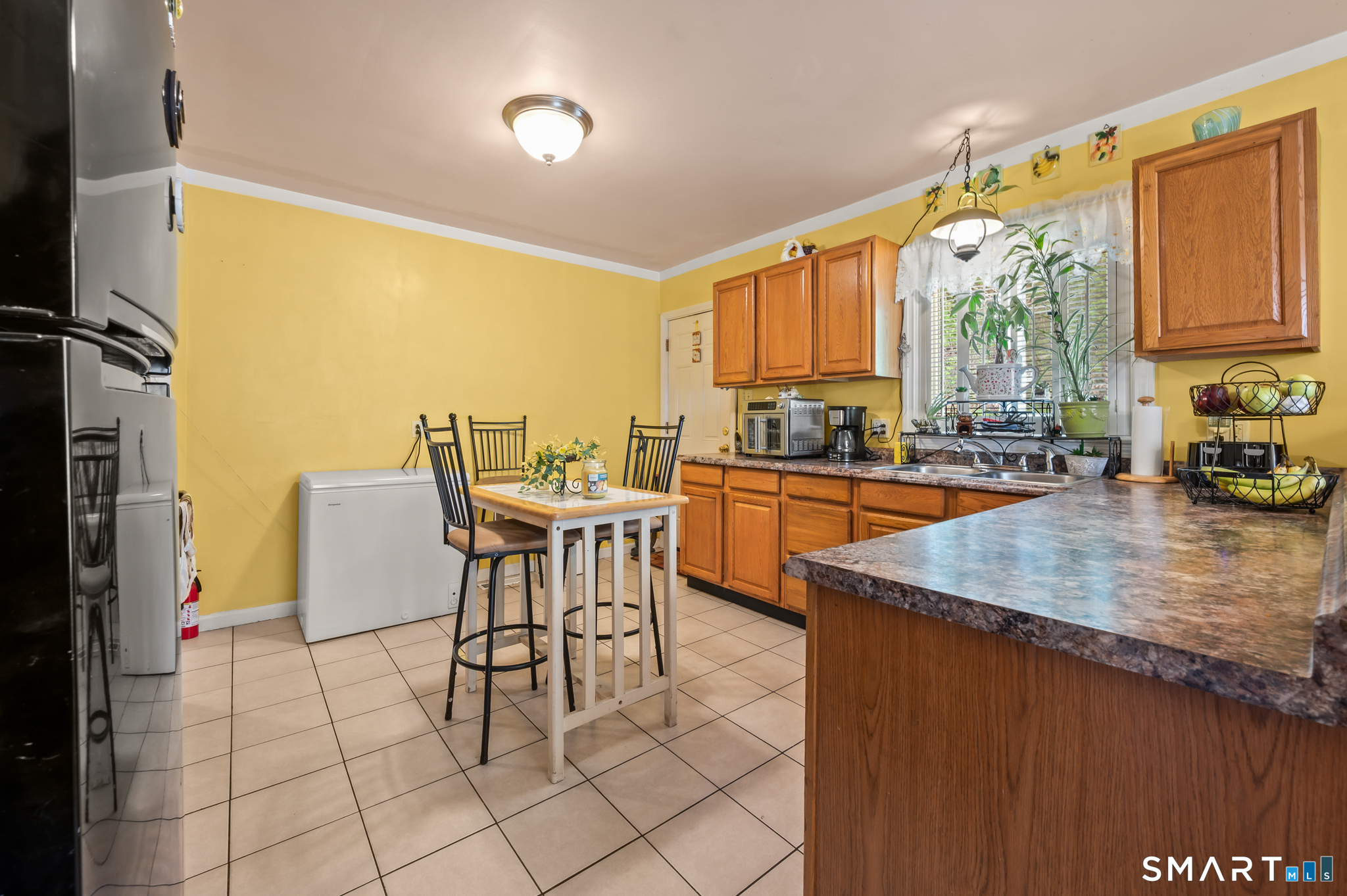 85 Dwight Street Ansonia, CT 06401 - Photo 10 of 40 a kitchen with stainless steel appliances granite countertop a sink a stove a refrigerator a dining table and chairs with wooden floor