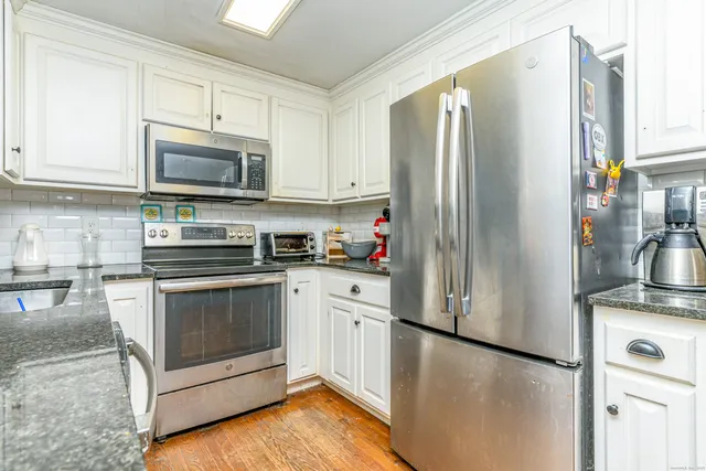 a kitchen with stainless steel appliances granite countertop a refrigerator stove a sink and a microwave