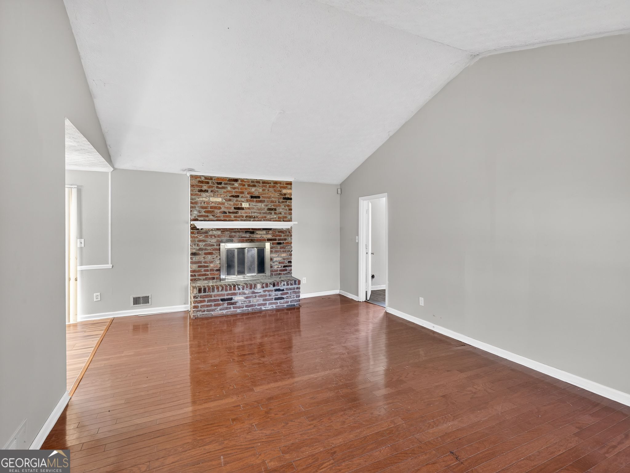556 Roy Huie Road Riverdale, GA 30274 - Photo 3 of 31 wooden floor in an empty room with a fireplace