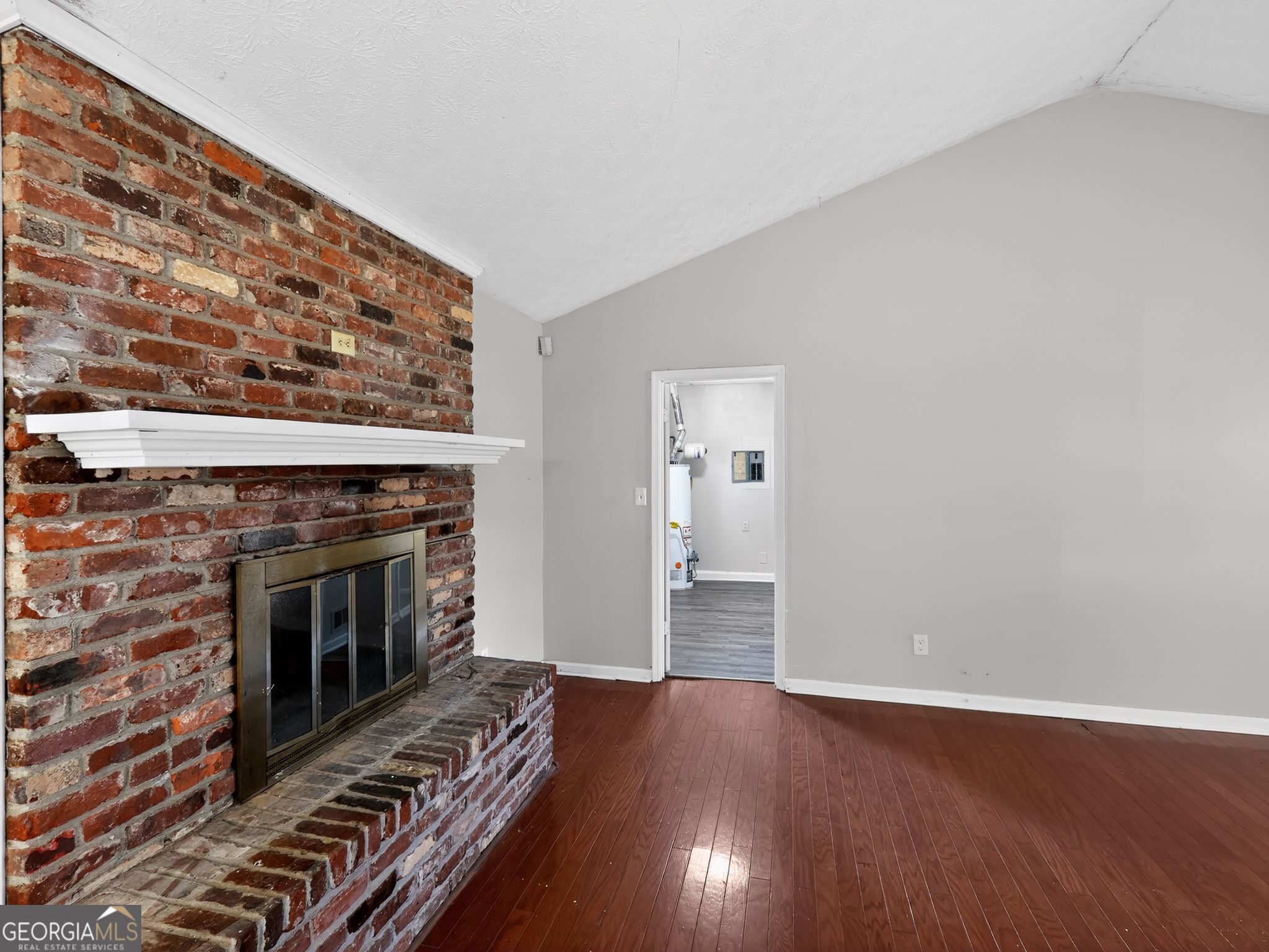 556 Roy Huie Road Riverdale, GA 30274 - Photo 7 of 31 a view of an empty room with wooden floor fireplace and a window