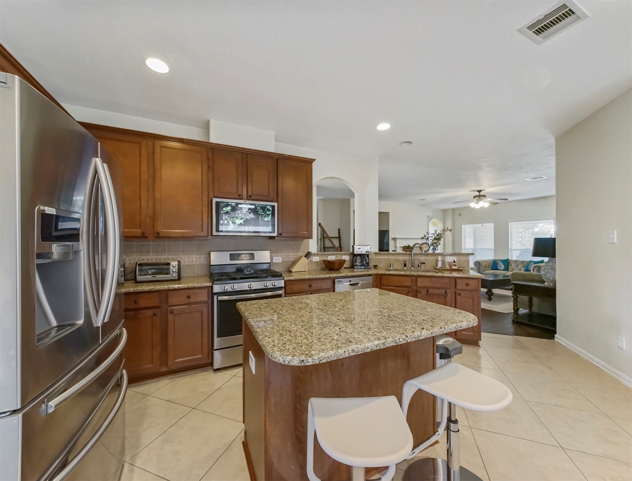 8214 Garrison Point Drive Houston, TX 77040 - Photo 5 of 37 a kitchen with stainless steel appliances granite countertop a stove top oven a sink a dining table and chairs