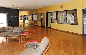 a living room with furniture floor to ceiling window and wooden floor