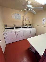 9301 Lime Bay Boulevard, Unit 204 Tamarac, FL 33321 - Photo 18 of 30 a room with wooden cabinets and white appliances