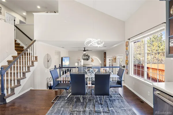 a view of a dining room with furniture a chandelier and wooden floor