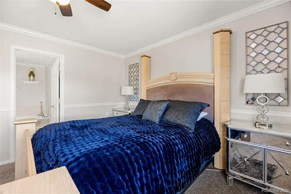 a bedroom with a bed a mirror and lamp