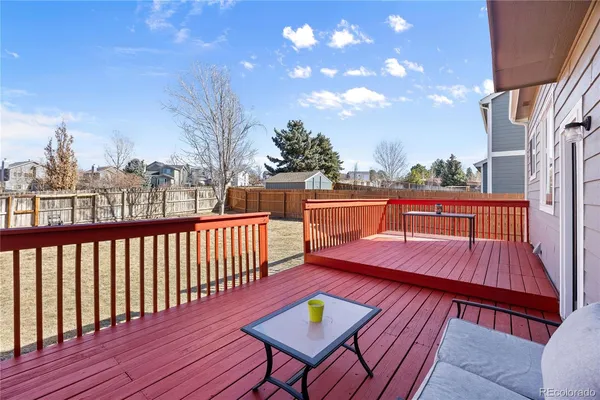 a balcony with wooden floor and outdoor seating
