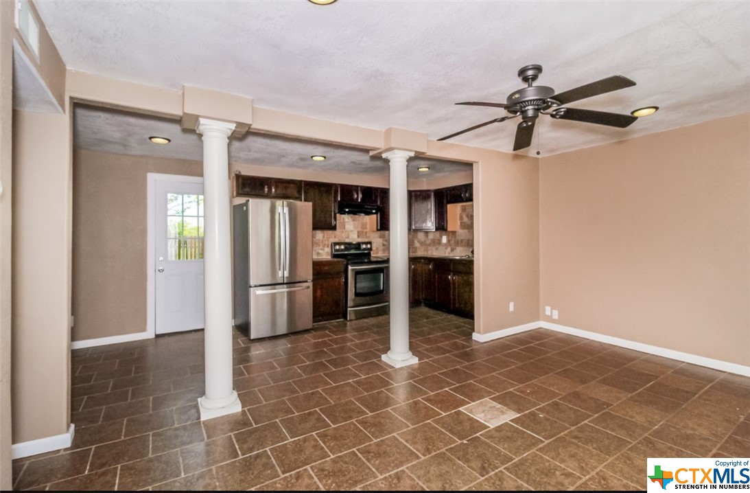 a kitchen with granite countertop a refrigerator and a stove top oven
