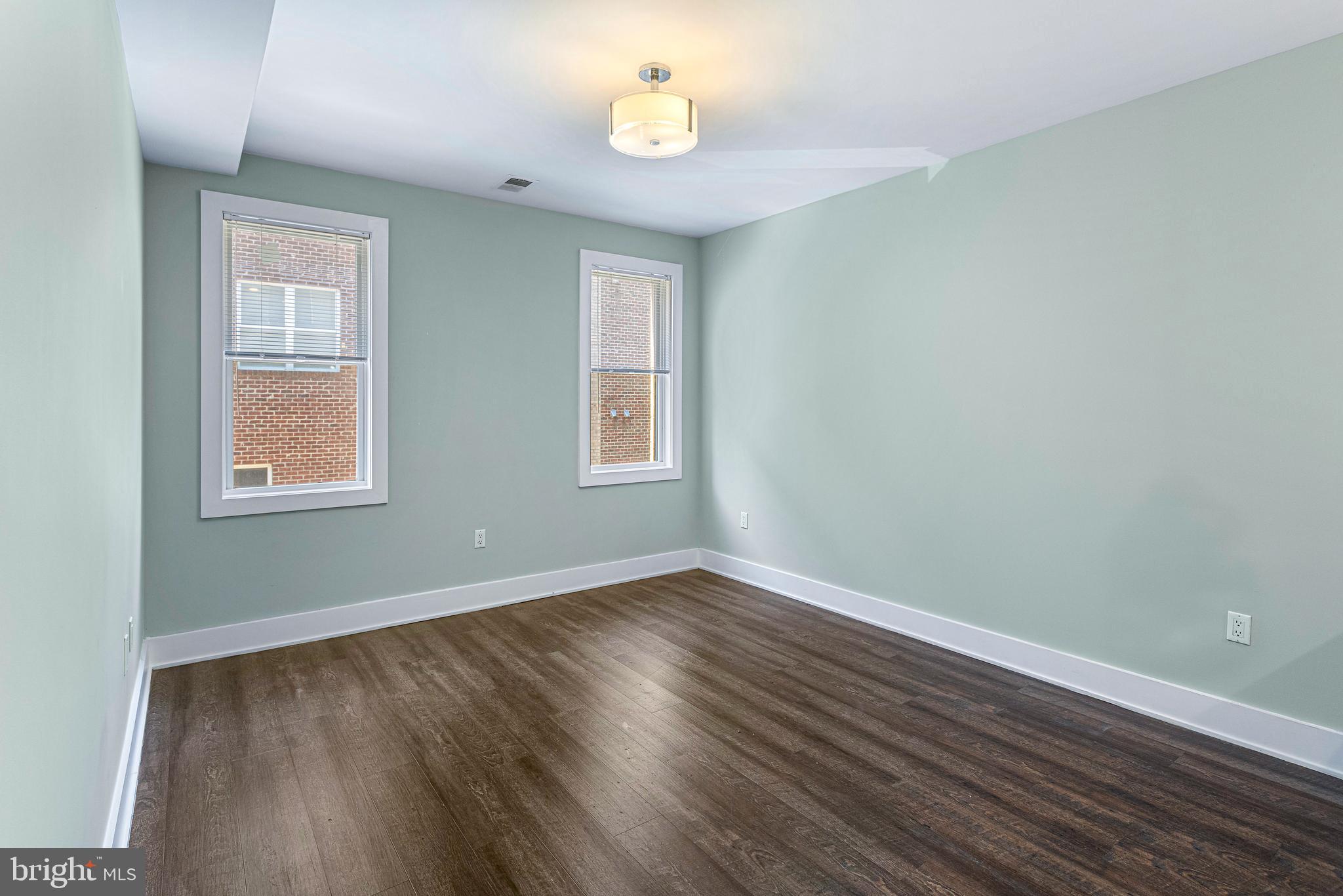 1219 K Street Northeast, Unit 202 Washington, DC 20002 - Photo 2 of 15 an empty room with wooden floor and windows