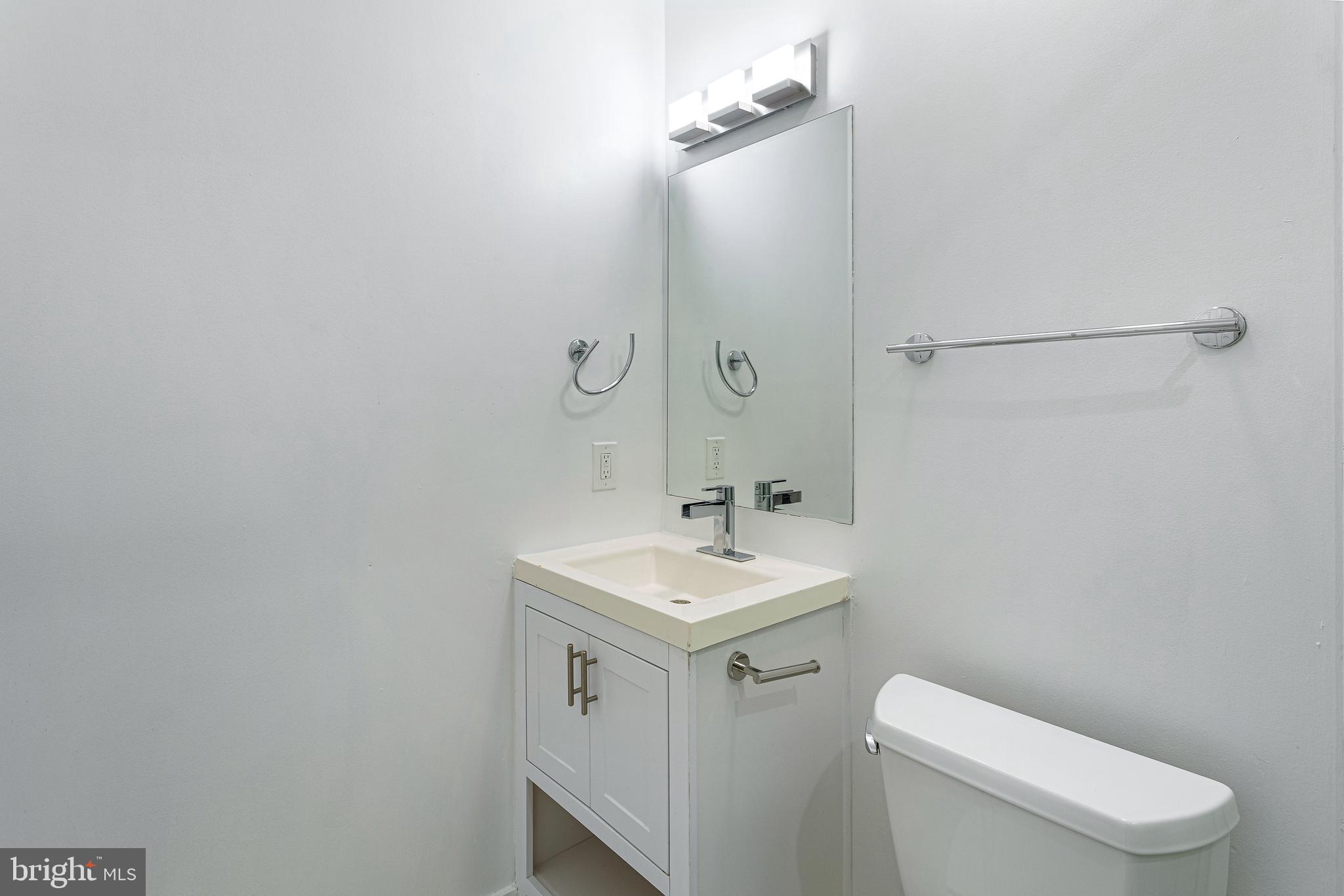 1219 K Street Northeast, Unit 202 Washington, DC 20002 - Photo 6 of 15 a bathroom with a toilet sink and mirror