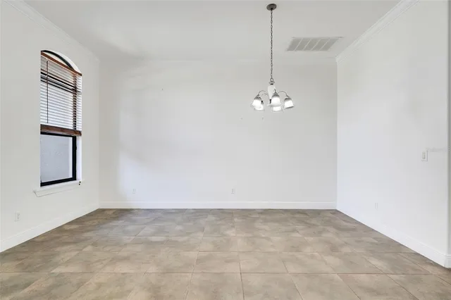 a view of an empty room with chandelier fan