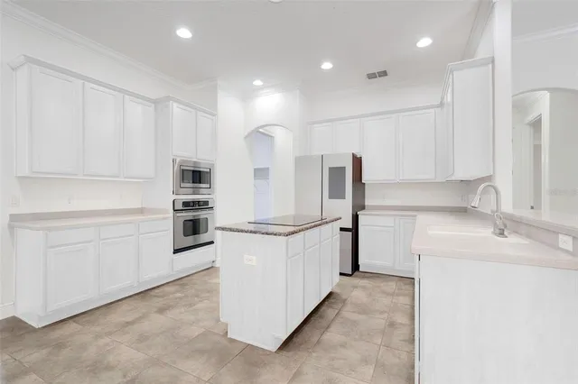 a kitchen with white cabinets and stainless steel appliances