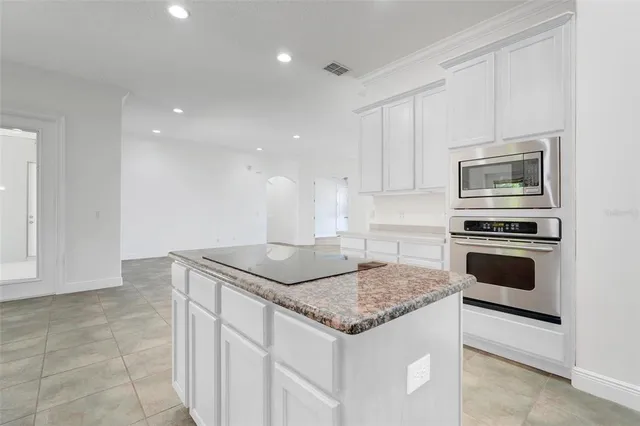 a kitchen with granite countertop a sink stove and cabinets