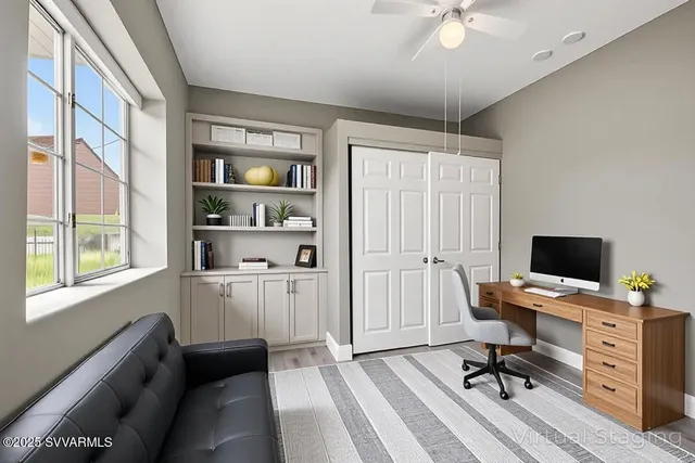 a view of a workspace with furniture and a window
