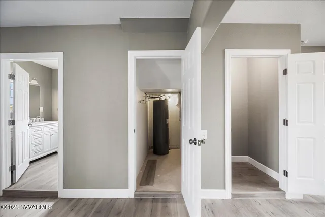 a view of a hallway with bathroom and wooden floor
