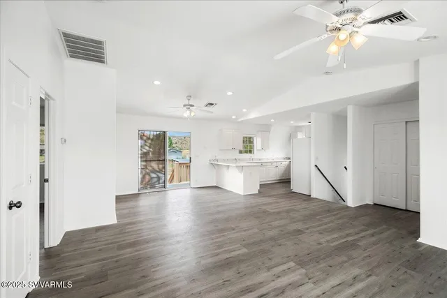 a view of a kitchen with wooden floor and a window