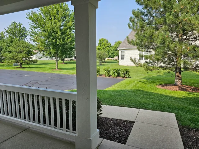a view of a house with a small yard and a large tree