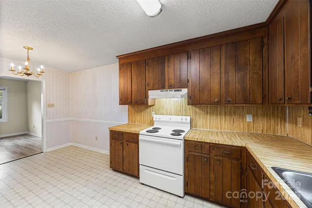 a kitchen with a stove cabinets and wooden floor