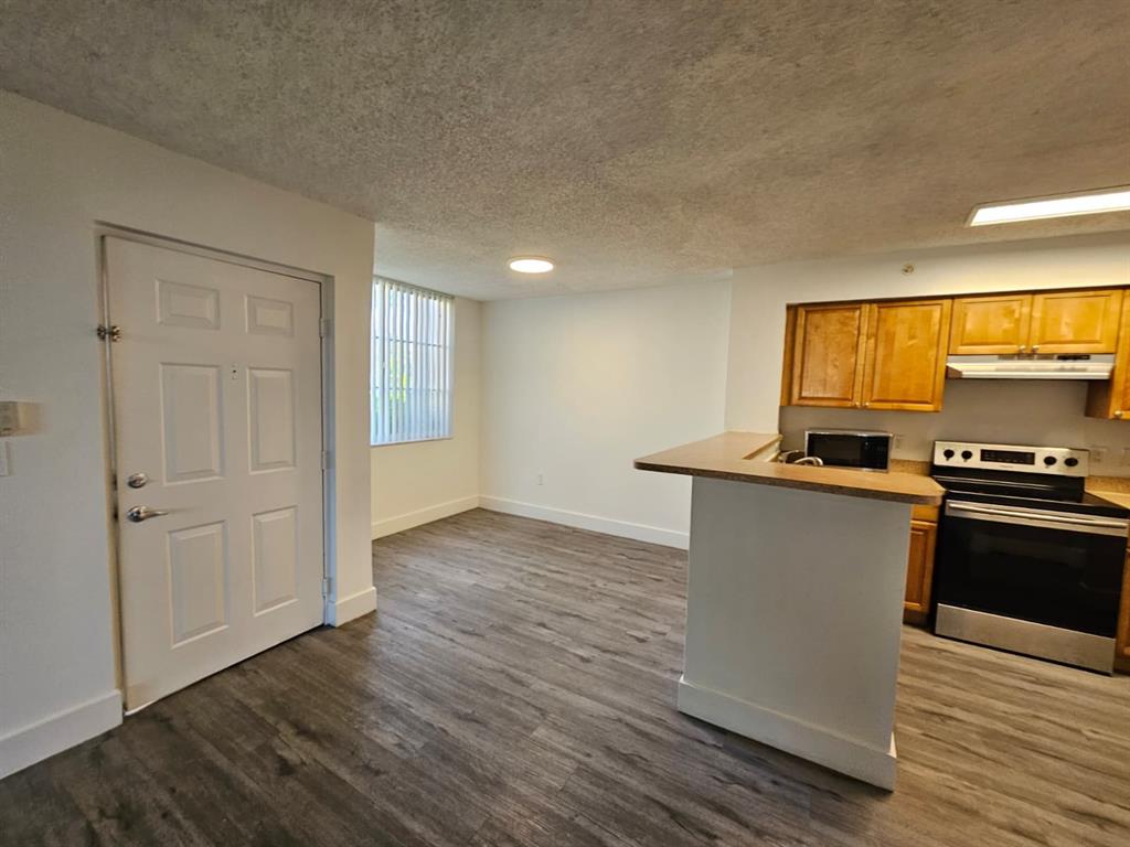 12118 St Andrews Place, Unit 108 Miramar, FL 33025 - Photo 8 of 15 a kitchen with a refrigerator and a stove top oven