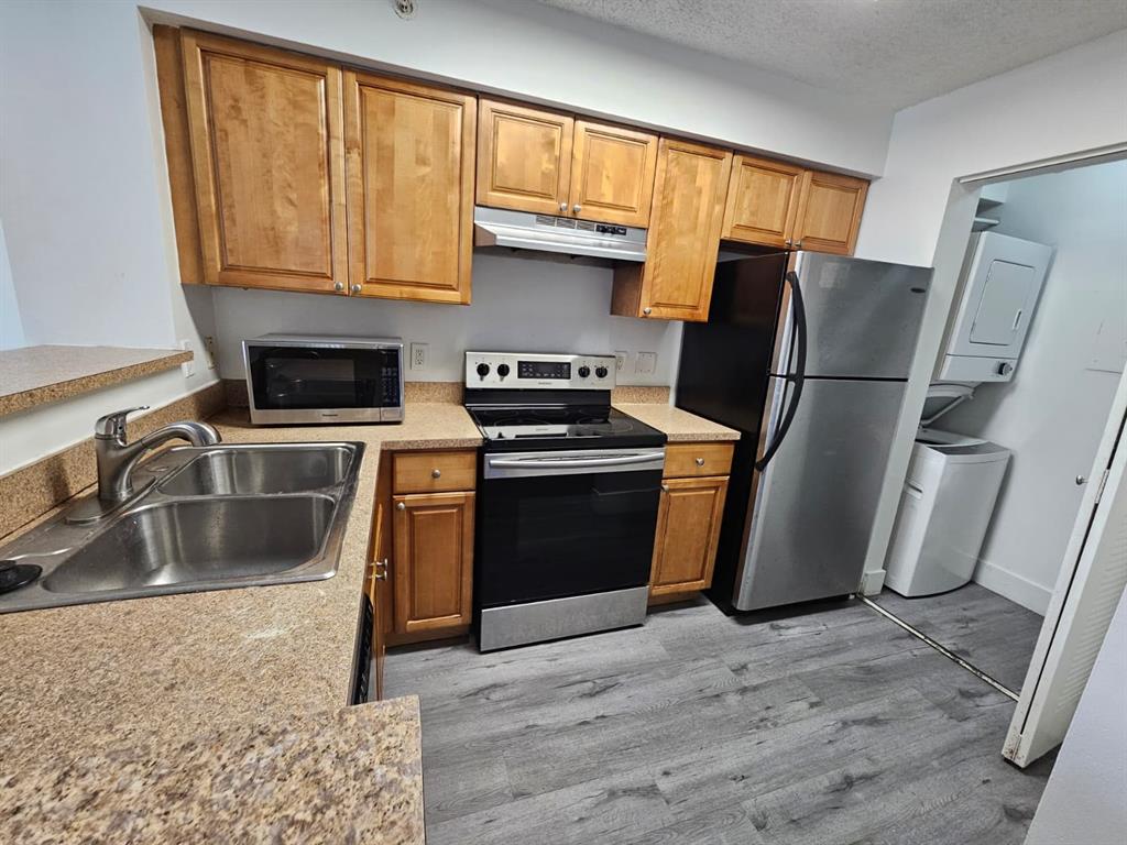 12118 St Andrews Place, Unit 108 Miramar, FL 33025 - Photo 10 of 15 a kitchen with granite countertop a refrigerator stove and sink