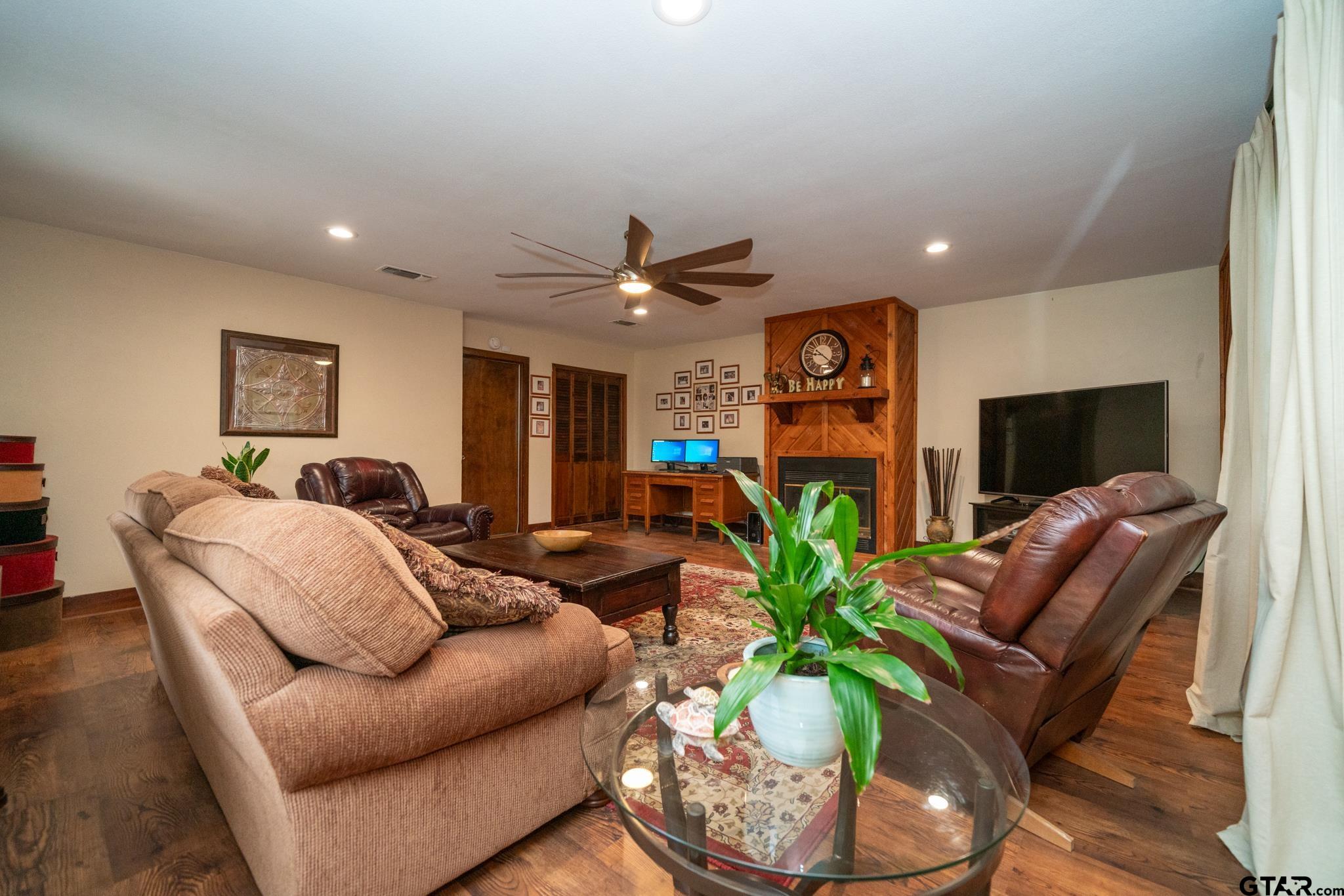 102 Randal Lane Pittsburg, TX 75686 - Photo 21 of 42 a living room with furniture a clock and a flat screen tv