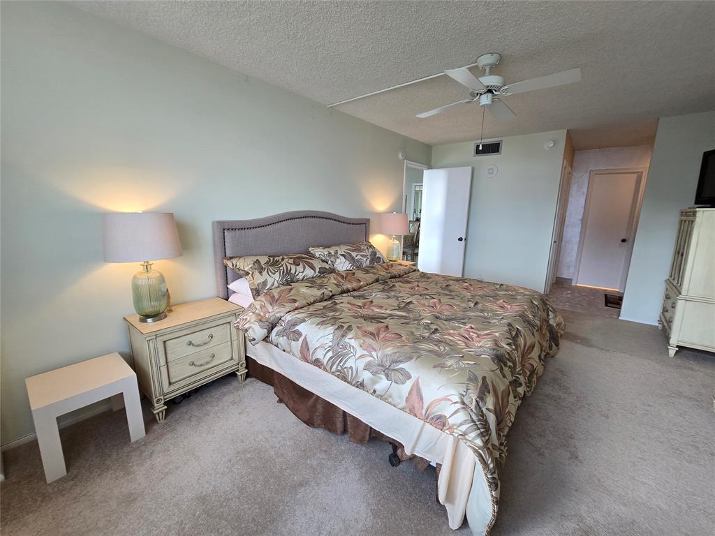 2000 South Ocean Boulevard, Unit 8F Lauderdale-by-the-Sea, FL 33062 - Photo 20 of 35 a spacious bedroom with a bed and a chandelier