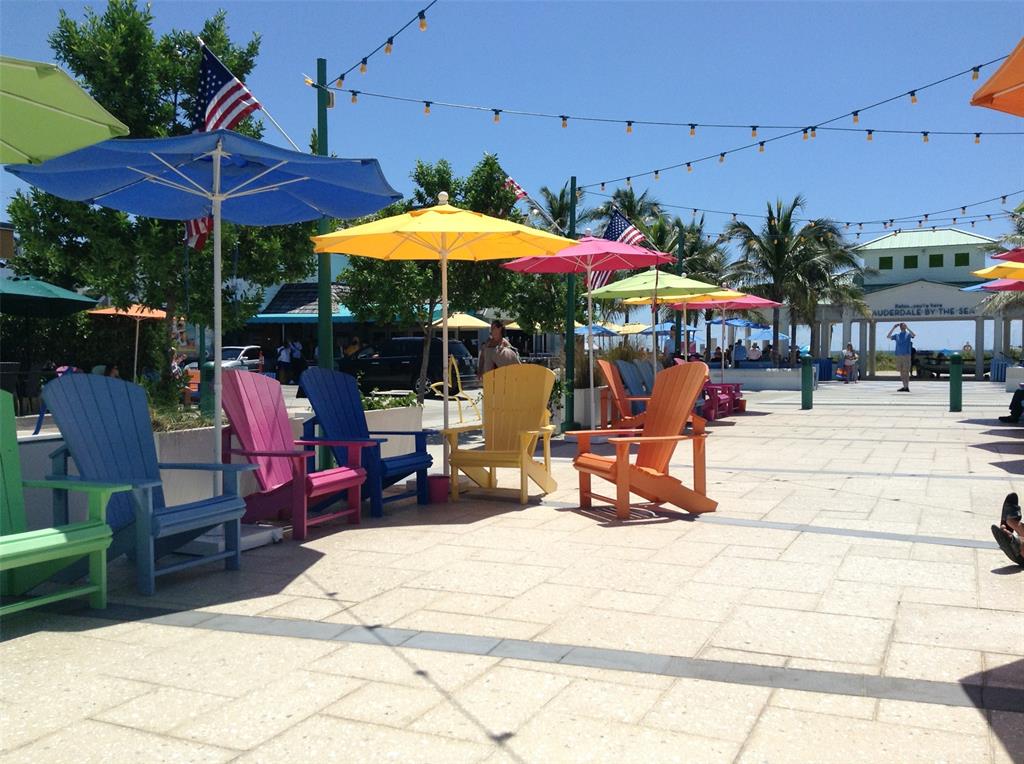 2000 South Ocean Boulevard, Unit 8F Lauderdale-by-the-Sea, FL 33062 - Photo 33 of 35 a view of a patio with a table and chairs under an umbrella