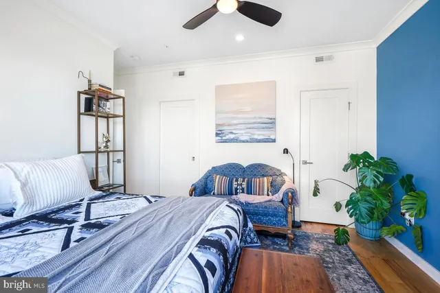 a bedroom with a bed dresser and a potted plant