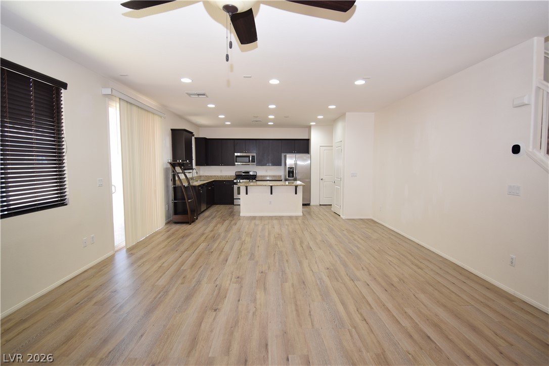 3622 Via Terracina Henderson, NV 89052 - Photo 3 of 22 An open concept living area boasts a modern kitchen with rich cabinetry and an inviting island, perfect for gatherings.