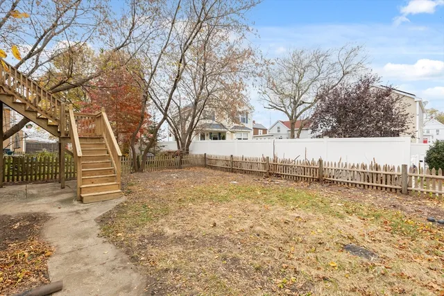 a view of a yard with wooden fence
