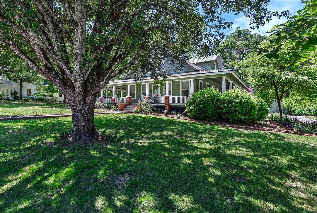 205 West Mauldin Street Walhalla, SC 29691 - Photo 36 of 43 A classic home boasts a full wraparound porch, framed by mature trees and lush green landscaping.